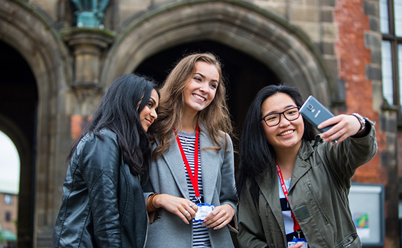Three female students at PARTNERS 2017 getting a selfie in front of the Arches