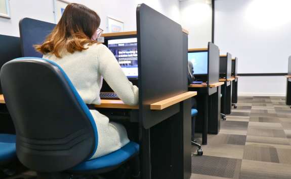 A Newcastle University Business School student sat at a workstation in the Experimental and Behavioural Economics Lab.