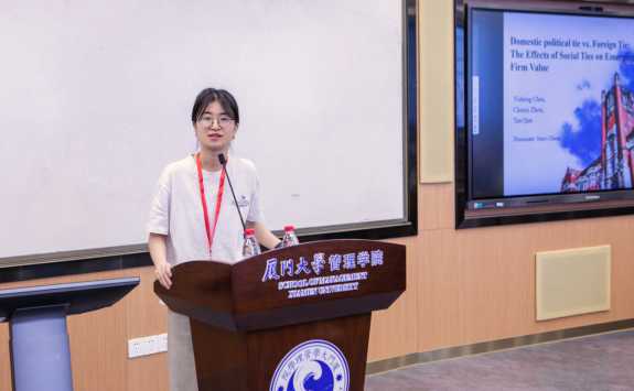 PhD student Jianyi Zhang presenting from a lectern at the Tri-Annual Conference 2023