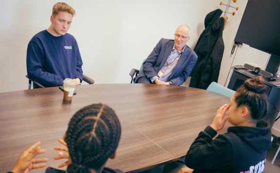 Basketball scholarship students Vivian Woo, Thomas Horvat, Daniel Delsol-Lowry and Nicolas Johnson sat around a meeting room table with the Dean of Newcastle University Business School, Stewart Robinson.