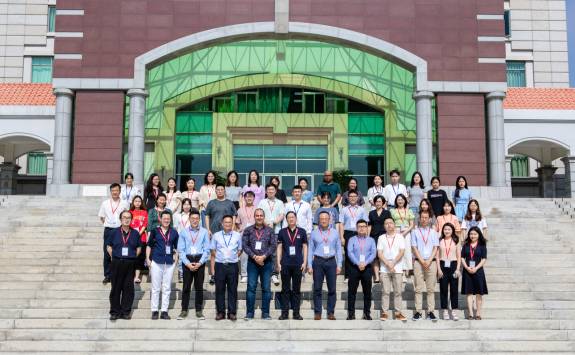 Group shot of the delegates of the 2023 Tri-Annual Conference stood on the steps outside the venue.