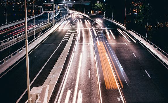 Cars driving along a highway at night.