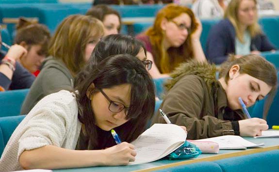 Students taking notes during a lecture.