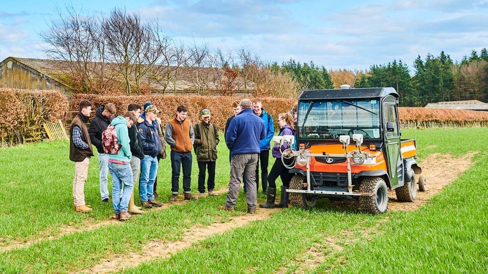 Students crowd round a farm vehicle at the University's Cockle Park Farm