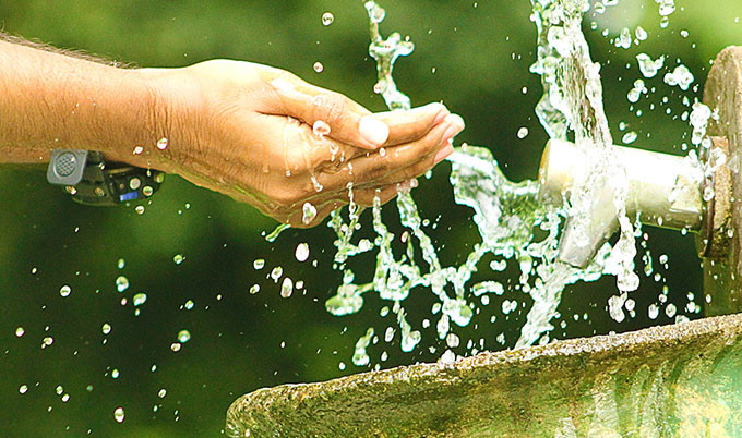 About Us: Meeting Challenges - washing hands in splashing water from a tap