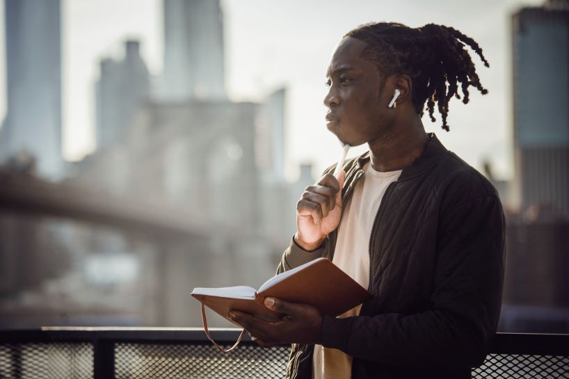 Student with notebook, looking reflective