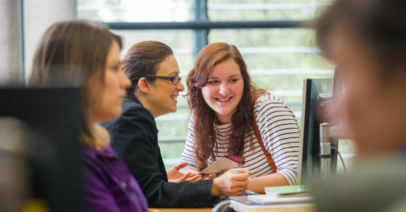 A student chats with a member of staff in Student Services. 