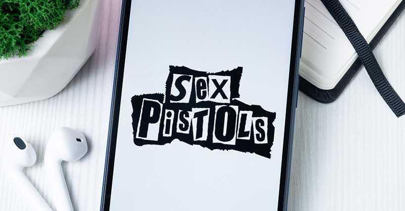 A mobile phone with the Sex Pistols displayed on it and ear buds
