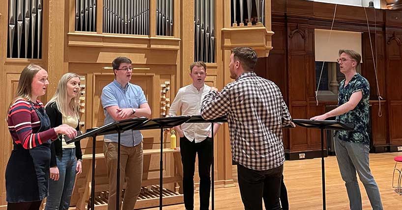 A choir practises in Newcastle university's King's Hall