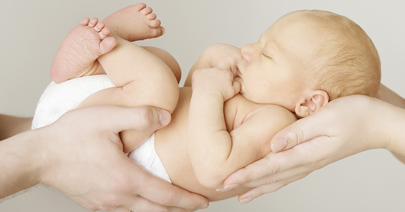 Small baby held by parents 