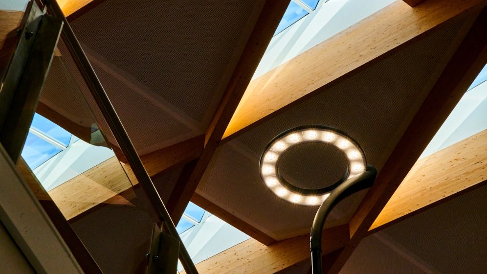 A close up of some of the building's internal lighting and the glulam roof structure.