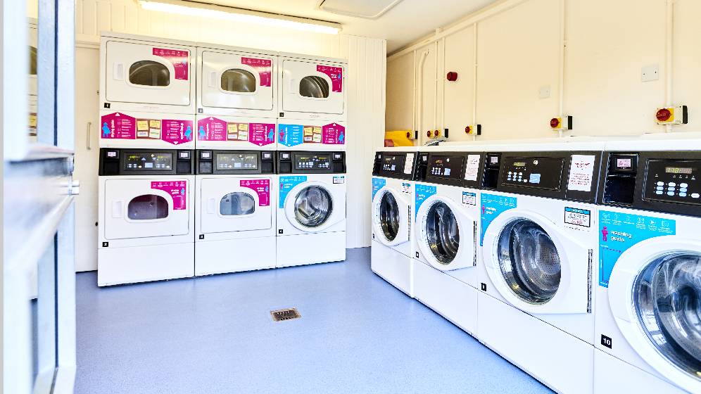 A row of washing machines and dryers in the laundry room at Bowsden Court