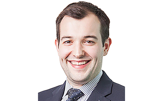 A smiling man in a navy suit and tie