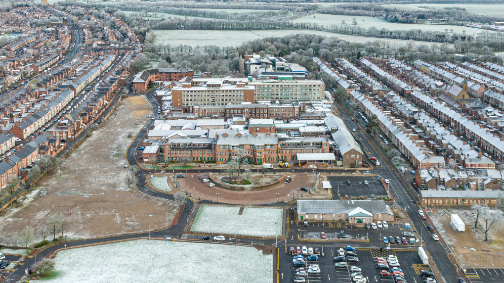 The front on view of the current buildings, showing the mix of used and unused building and the space there is for redevelopment. In the background you can see the stretch of the town moor. On each side are streets of terrace housing. The old general hospital building is in the centre