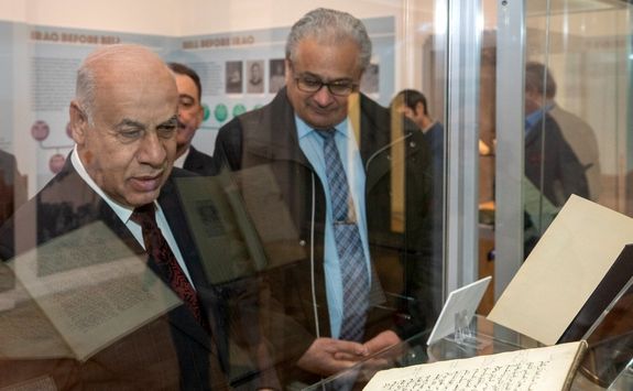 Iraqi guests look into a display cabinet containing pieces from the Gertrude Bell archive.