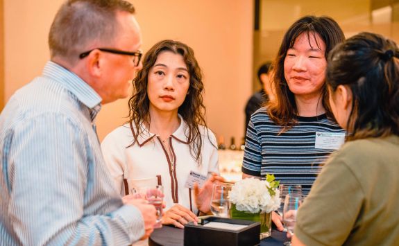 Chris Soan engaging in a group discussion with three female alumni attendees at an event in China.