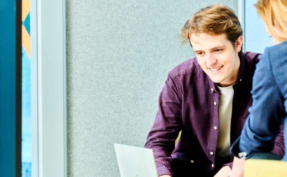 A Business School student looking at a laptop with NUBS Careers Consultant Jo Craggs