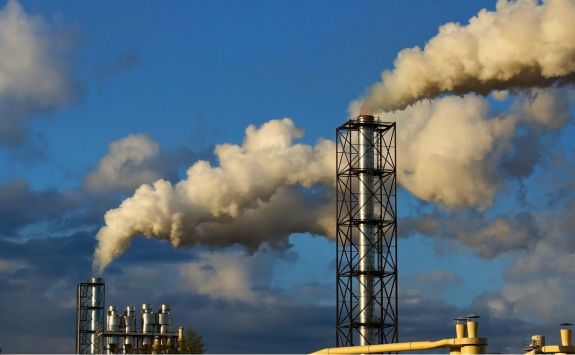 A chemical plant with smoke billowing from its chimneys.