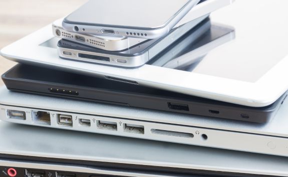 A stack of various modern mobile devices and laptops showcasing different ports and connectivity options.	