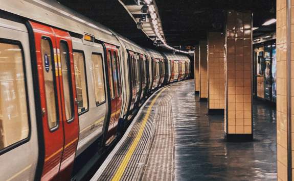 A red and white underground train standing at an empty station