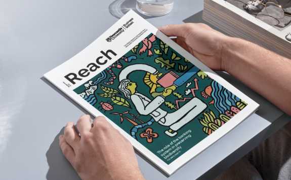 Hands holding the September 2023 issue of Reach magazine from Newcastle University Business School