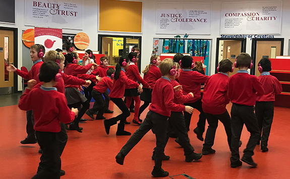 Children in hall having fun with headphones on