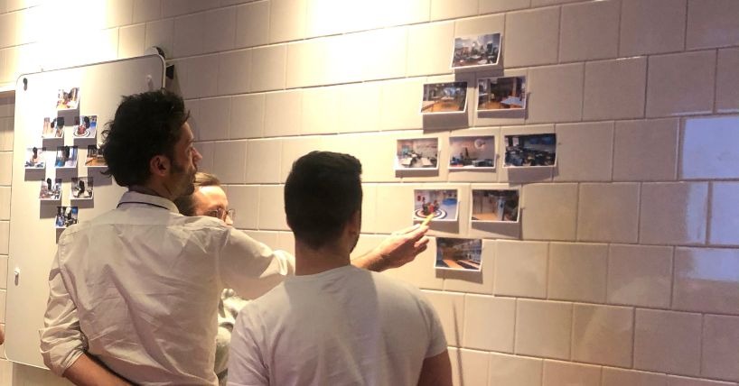 teachers looking at a completed diamond ranking activity pinned on a wall
