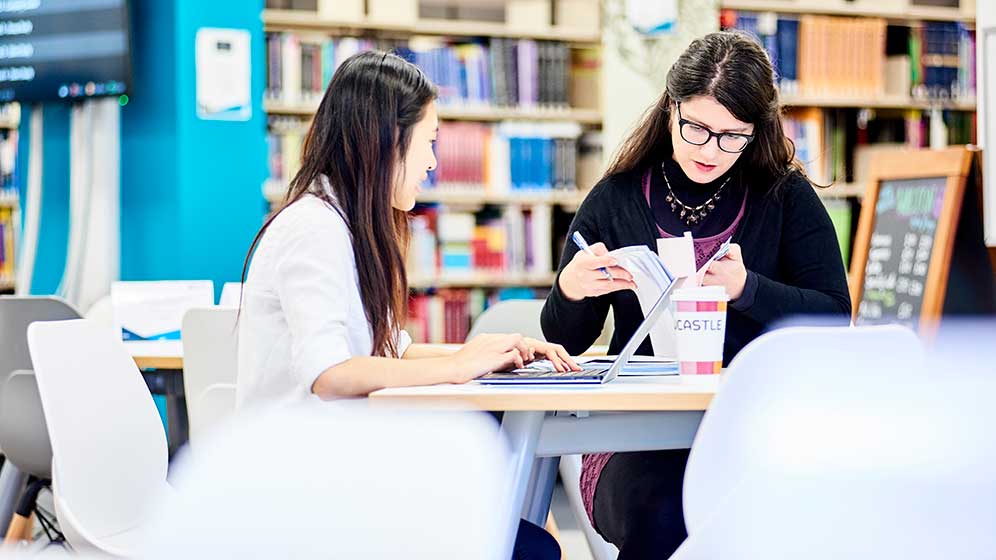 Two students working together in the dental school library.