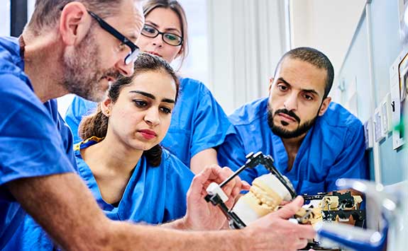 Researchers in the dental school analyse an x-ray.