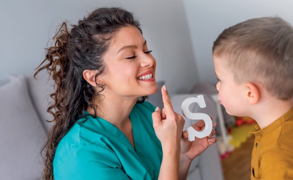 a language teacher shows a young student how to pronounce 