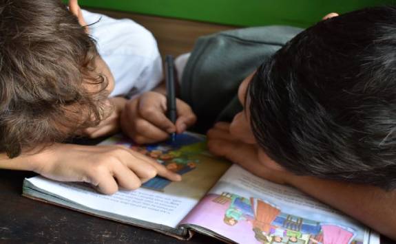 Two kids reading a book