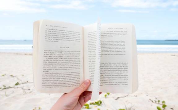 open book with a beach in the background