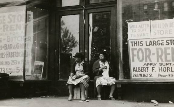 two women sat outside an empty shop