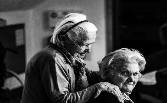 an elderly woman giving a massage to another elderly woman