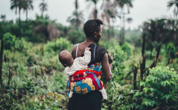 a woman carrying a baby on back