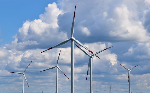 Several wind turbines dispersed across a green field.