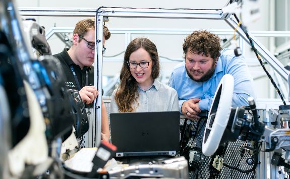 A team of engineers working on a car.