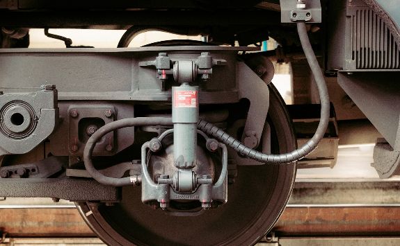 A train wheel on a train sitting on railway tracks.