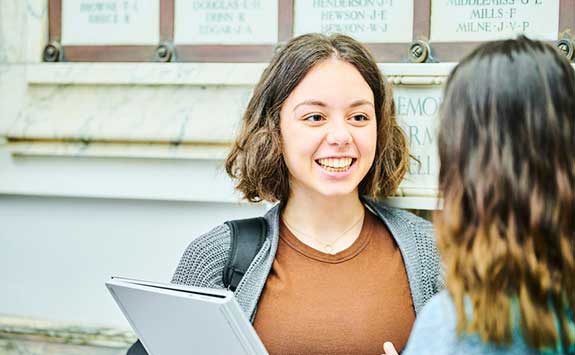 two female students chatting outside the Armstrong building 