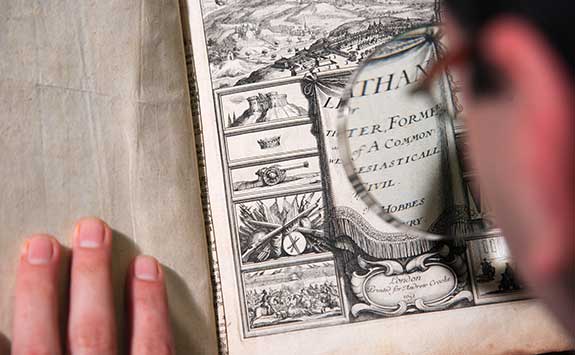 A postgraduate researcher examines an historic text.