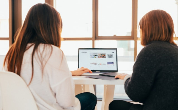 Two people sat in front of a computer