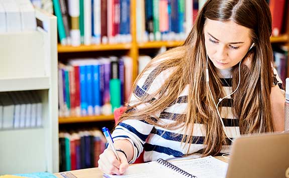 A Masters students studies alone in the Law Library.