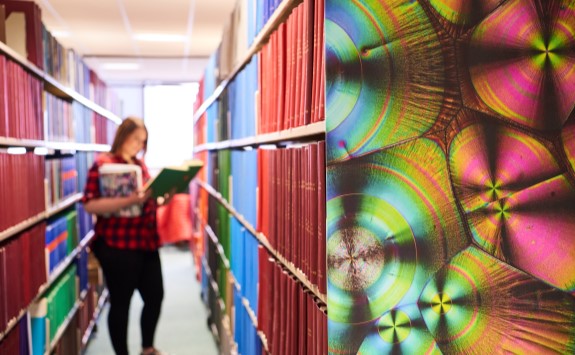 Student browsing the library bookshelves