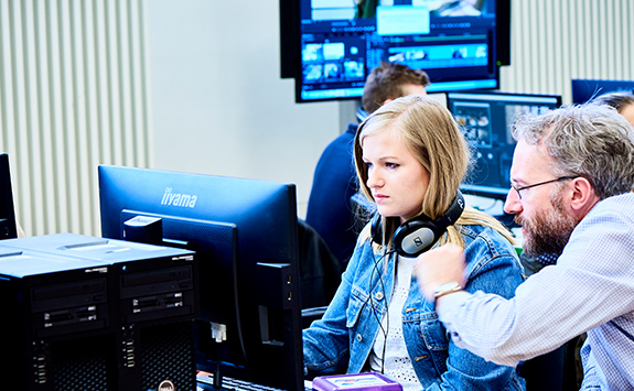 A student and instructor working together in a computer lab