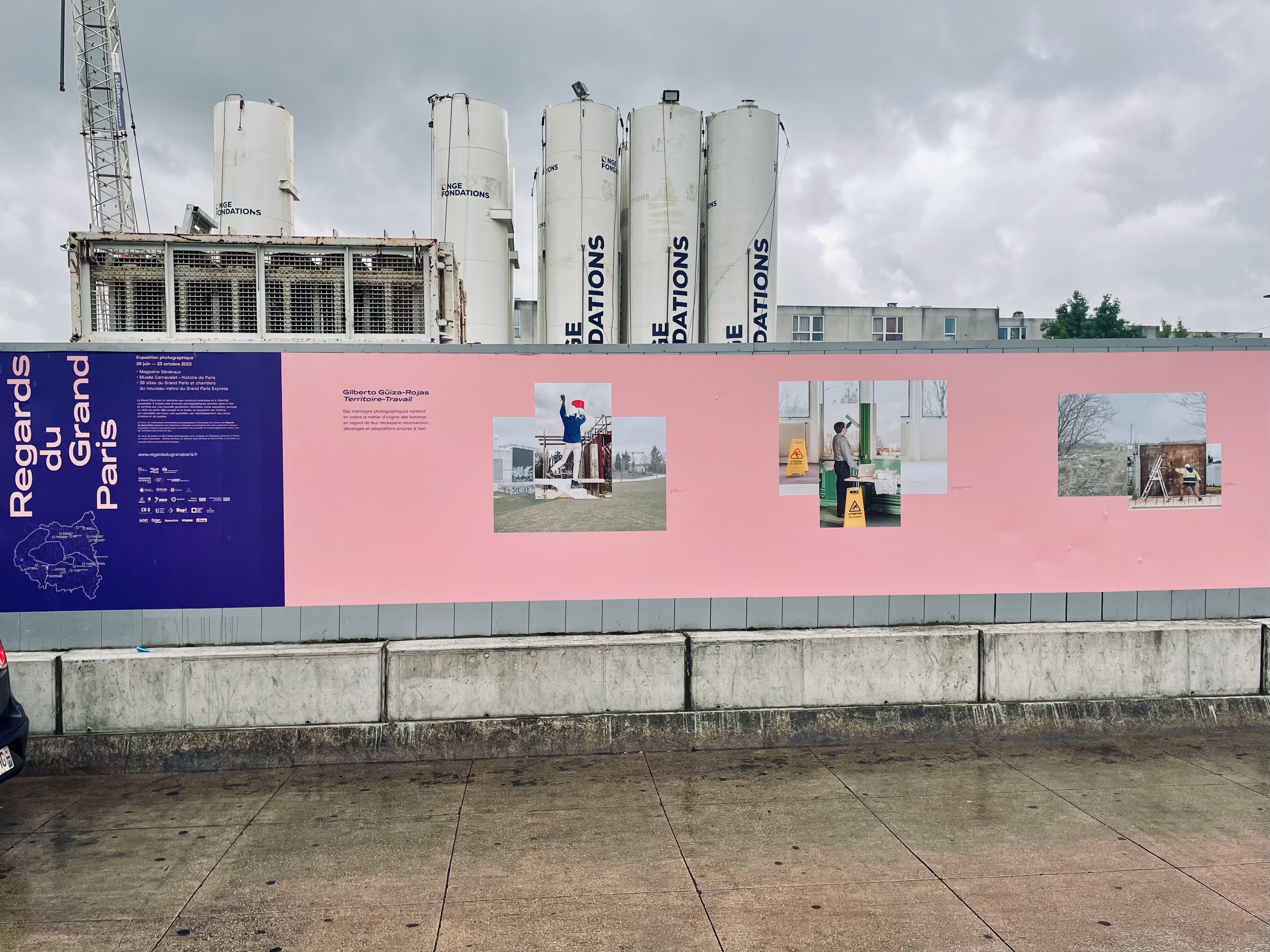 Construction site in Paris with pink partition wall sprinkled with information