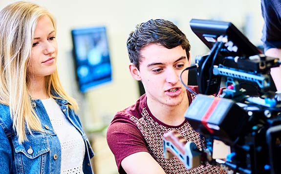 two students work together on a piece of film equipment