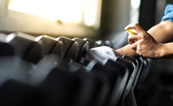 A cleaner cleaning gym equipment.