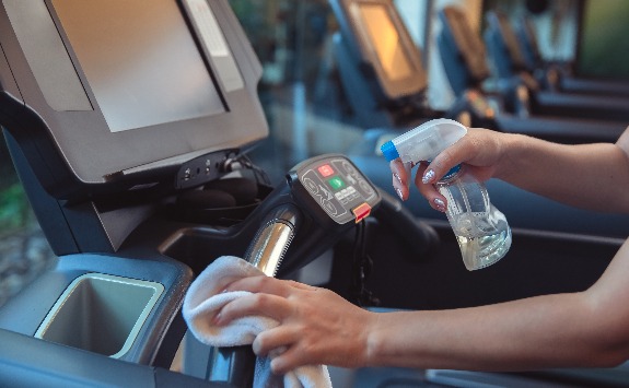 A cleaner cleaning gym equipment.