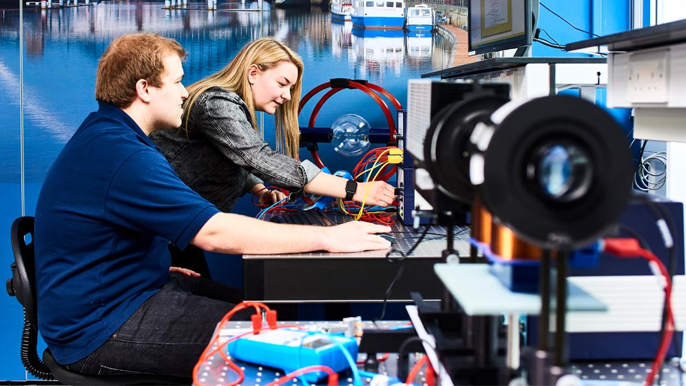 Two students using some physics equipment