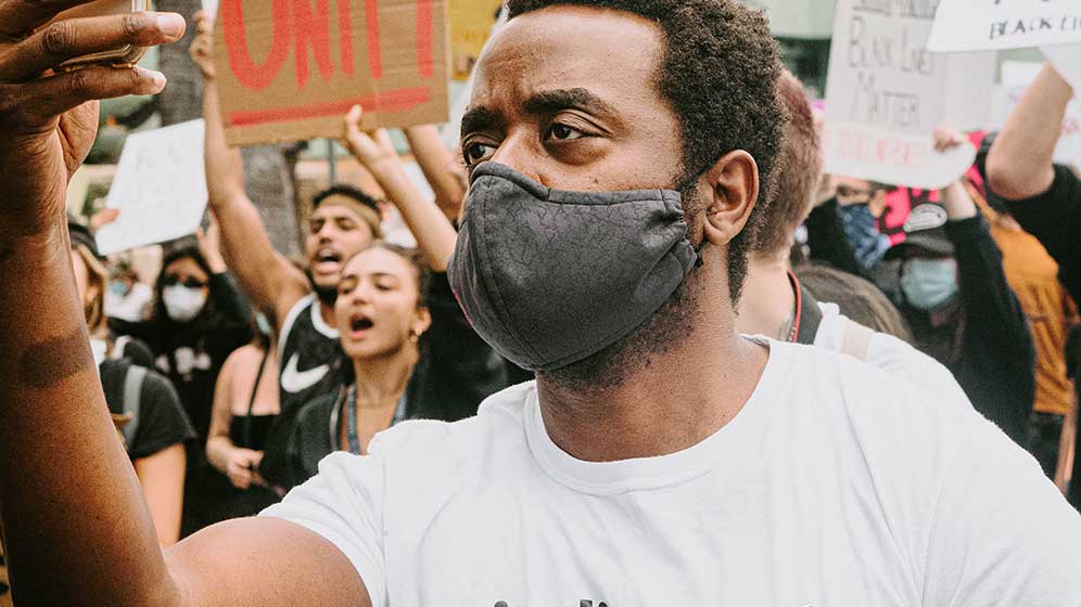 Man at a protest wearing face mask.